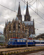   Die TRI 110 428-0 (91 80 6110 428-0 D-TRAIN), ex DB E 10 428, steht mit einem National Express Zug am 22.12.2018 im Hauptbahnhof Köln, vor der wohl weltweit größten Bahnhofskapelle,