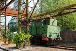 Krupp Bergbau/906071/etwas-fuer-fotos-unguenstig-stehend-die Etwas für Fotos ungünstig stehend, die Verschub-Dampflokomotive Emil Mayrisch 5, eine Krupp Bergbau, am 05 Juni 2011 im LWL-Industriemuseum Henrichshütte in Hattingen (bis 2007 WIM - Westfälisches Industriemuseum).

Die Krupp Typ Bergbau wurde 1953 Lokomotiv- und Waggonbaufabrik Krupp (LOWA) der Friedrich Krupp AG in Essen unter der Fabriknummer 3077 gebaut und als Lok IX an die Gewerkschaft Auguste-Victoria in Marl-Sinsen. Bis zu seiner Schließung 2015 war das Bergwerk das drittletzte aktive Steinkohlebergwerk Deutschlands sowie das zweitletzte im Ruhrgebiet.

1968 ging die Lok aber an die Grube Anna in Alsdorf des EBV - Eschweiler Bergwerks-Verein AG und wurde 1983 als ANNA Nr. 7 geführt, von 1983 bis zur Ausmusterung 1992 wurde die Lok 'Emil Mayrisch 5' geführt. Im Jahr 1993 ging sie an das Bergbaumuseum Wurmrevier e. V. in Alsdorf und ging aber ende der 1990er an das damalige als geführt WIM - Westfälisches Industriemuseum, Standort Henrichshütte in Hattingen. 

Beschreibung des Typs 'Bergbau' der Lokomotivfabrik Krupp (Essen):
Die normalspurige, vierachsige Tenderlokomotive war Teil des Nachkriegs-Typenprogramm Lokomotivfabrik in Essen und wurde sowohl in einer Naßdampf- als auch in einer Heißdampfversion geliefert. Zwischen 1948 und 1962 entstanden 30 Lokomotiven dieses Typs in der Lokomotivfabrik Krupp AG. Die 'Bergbau' war nicht nur die leistungsstärkste, sondern mit Abstand mit 80 t die schwerste Maschine unter den Nachkriegsbauarten. 

Entstehungsgeschichte:
Während des Zweiten Weltkrieges erhielt Krupp den Auftrag zur Entwicklung einer schweren Dh2t-Lokomotivbauart für die Reichswerke Hermann Göring in Salzgitter, nach 1945 ging diese endgültig in der Salzgitter AG auf, die sich bis Ende der 1980er Jahre im Besitz der Bundesrepublik Deutschland befand. Nach Abschluss der Konstruktionsarbeiten wurde der Bau der 13 bestellten Maschinen kriegsbedingt zur Firma Werkspoor in Utrecht verlagert. Die Niederlande war ja von den deutschen Truppen besetzten worden. Bis zum Kriegsende konnte allerdings keine Lok fertig gestellt werden. Die angearbeiteten Baugruppen wurden kurz vor dem Abzug der Besatzungstruppen noch nach Essen überführt, wo sie nach Komplettierung und Endmontage ab 1948 zur ersten Serie der Bergbau wurden. 

Bauart:
Die Krupp Bergbau war für den schweren Übergabe- und Verschubdienst von Industrie- und Werksbahnen konzipiert. Entsprechend diesem Einsatzzweck war sie besonders robust und kräftig ausgeführt. Dank ihres vergleichsweise hohen Kesseldrucks, der großen Zylinder und des günstigen Übersetzungsverhältnisses war die mit vollen Vorräten 80 t schwere und rund 1.000 PSi starke Lok nicht nur die leistungsfähigste Type des Krupp-Industrielokprogramms, sondern die schwerste und stärkste vierachsige deutsche Tenderlok überhaupt. Im unteren Geschwindigkeitsbereich übertraf ihre Zugkraft sogar die der sechsachsigen Schlepptenderlok der Baureihe 50. Die zulässige Höchstgeschwindigkeit betrug 50 km/h. Zwecks Erzielung günstiger Kurvenlaufeigenschaften lagen nur der erste und dritte Radsatz fest im Rahmen, der zweite und vierte Radsatz waren jeweils um 15 mm seitenverschiebbar.

Die Type wurden in mehreren Baulosen gefertigt, die sich teilweise äußerlich unterscheiden lassen; die ersten beiden Serien besaßen viereckige Führerhausstirnfenster nach Art der Kriegslokomotiven, kantige Führerhausdächer und zwei sichtbare Kesselaufbauten (Dampfdom mit zwei Sandkästen unter gemeinsamer Verkleidung, separater Speisedom); später gebaute Loks hatten ovale Stirnfenster, abgerundete Führerhausdächer sowie eine durchgehende Verkleidung von Speisedom, Dampfdom und nur noch einem Sandkasten. Da sich der Wasservorrat von zunächst 8 m³ bei den auf der Hafenbahn der HOAG (Walsum – Oberhausen) eingesetzten Loks als etwas knapp erwiesen hatte, wurde ein Teil der später gebauten Maschinen mit vergrößerten hinteren Vorratsbehältern ausgerüstet. Der hintere Überhang wuchs dadurch um 150 mm, der Wasservorrat nahm auf 10 m³ zu. Einige Maschinen wurden ab Werk mit einem Mischvorwärmer ausgerüstet.

TECHNISCHE DATEN:
Gebaute Anzahl: 30
Baujahre: 1948 bis 1962
Bauart: D n2t oder D h2t
Spurweite: 1.435 mm (Normalspur)
Länge über Puffer: 11.100–11.250 mm (je nach Bauserie)
Höhe: 4.150 mm
Breite: 3.130 mm
Gesamtachsstand: 4.500 mm (3 x 1.500 mm)
Treibraddurchmesser: 1.200 mm (neu)
Dienstgewicht: 80 t
Höchstgeschwindigkeit: 50 km/h (vorwärts / rückwärts), diese zuletzt 25 km/h
Indizierte Leistung: 735 kW / 1.000 PS
Anfahrzugkraft: 223 kN
Kesselüberdruck: 15 bar
Zylinder: 2 (Ø 630 mm x 600 mm Hub)
Steuerungsart: Heusinger auβen
Rostfläche: 2,46 m² 
Überhitzerfläche: 42 m² 
Verdampfungsheizfläche: 118 m²
Wasservorrat: 10,0 m³
Kohlevorrat: 3 t
Kleinster bef. Halbmesser: 100 m
Bremse: Knorr 
