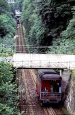 Malbergbahn in Bad Ems, eine Wasserballastbahn am 15.07.1979. 
Am 5.Juni 1887 nahm die Malbergbahn AG als erste Standseilbahn mit Wasserballast in Deutschland den regelmigen Betrieb auf. Die Steigung war mit 54,5 % die steilste Bergbahn in Deutschland zu der Zeit. 
Die Zahnstange System Riggenbach diente als Bremsstange. Bei einer durchschnittlichen Geschwindigkeit von 1,5 m/sec betrug die Fahrzeit 6 Minuten. Dabei rollte der obere, mit bis zu 4500 l mit Wasser gefllte Wagen zu Tal und zog ber eine Umlenkrolle an der Bergstation, den unteren Wagen hinauf. Die Wagen sind mit einer Spindelbremse und einer selbststndig wirkenden Bremse mit Fliehkraftregler ausgerstet.