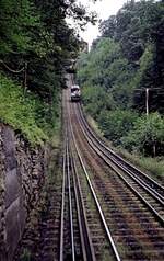 Malbergbahn in Bad Ems, eine Wasserballastbahn am 15.07.1979. 
Am 5.Juni 1887 nahm die Malbergbahn AG als erste Standseilbahn mit Wasserballast in Deutschland den regelmigen Betrieb auf. Die Steigung war mit 54,5 % die steilste Bergbahn in Deutschland zu der Zeit. 
Die Zahnstange System Riggenbach diente als Bremsstange. Bei einer durchschnittlichen Geschwindigkeit von 1,5 m/sec betrug die Fahrzeit 6 Minuten. Dabei rollte der obere, mit bis zu 4500 l mit Wasser gefllte Wagen zu Tal und zog ber eine Umlenkrolle an der Bergstation, den unteren Wagen hinauf. Die Wagen sind mit einer Spindelbremse und einer selbststndig wirkenden Bremse mit Fliehkraftregler ausgerstet.
Die Bergfahrt ist gerade gestartet, das Zugseil liegt links im Gleisbett.