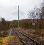 Die Hellertalbahn (KBS 462 / Strecke 2651) bei km 88,4 in Herdorf nahe dem Hp Knigsstollen am 18.03.2023. Ab den 20.03.2023 sollen die Triebzge der RB 96 „Hellertalbahn“, anstelle von Neunkirchen (Siegerland), nun bis zum Hp Knigsstollen gefhrt werden. Dafr wurden Vorbereitungen getroffen.

Vom Bahnhof Herdorf gibt es eine vorbergehende Langsamfahrstelle (40 km/h). Hier beim Hp Knigsstollen wurde Lf 3 – Endscheibe gesetzt, diese bedeutet: Ende der vorbergehenden Langsamfahrstelle (hier 40 km/h). Die Geschwindigkeitsbeschrnkung in der Langsamfahrstelle ist aufgehoben. Der Lokfhrer kann wieder auf die Streckengeschwindigkeit beschleunigen. Wobei den Sinn kann ich nicht ganz verstehen, denn ca. 5 m weiter ist ja die Sh 2 - (Schutz-)Halttafel, dieses ist auch bereits durch einen Geber (Sicherungstechnik) abgesichert. 

Ca. 100 m weiter hinten sitzt zudem die neue Gleissperre. Und weiter hinten ist die Gefahrstelle (der Einschnitt) wo es links am 23.12.2022 zu einem Felsstutz kam. Rechts vom Gleis (vom alten 2. Gleis) hatten bereits umfangreiche Hangsicherungsmanahmen stattgefunden. Hatte da vielleicht damals jemand die Seiten vertauscht;-)

