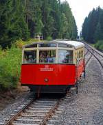 kbs-563-oberweisbacher-bergbahn/291733/fahrt-mit-der-oberweissbacher-bergbahn-am Fahrt mit der Oberweibacher Bergbahn am 24.08.2013, der Wagen 1 - der Personenwagen der Standseilbahn befindet sich auf Talfahrt und kommt uns in der Mitte (zwischen Obstfelderschmiede und Lichtenhain) entgegen.

Der Personenwagen, im betrieblichen Umgang als Wagen 1 bezeichnet, ist seit der Erffnung 1923 nur an den Stirnseiten leicht verndert worden. Das erfolgte 1959, als er grere Stirnfenster erhielt und die leicht ausgestellte Stirnpartie. Bei der Rekonstruktion  2002 wurde die Fahrradbhne angebaut. Besonderheit, sie ist nur am Fahrgestell befestigt und kann 8 Fahrrder aufnehmen.

Bergbahntechnik einer ganz besonderen Standseilbahn
Die Bergbahn besteht aus zwei Teilen:
- der Standseilbahn, von Obstfelderschmiede nach Lichtenhain und
- der 'Flachstrecke' der Bergbahn, von Lichtenhain nach Cursdorf

Die Konzession zum Bau wurde fr eine Eisenbahnstrecke von Obstfelderschmiede nach Cursdorf erteilt, heute als Strecke Nr. 6691, KBS 563, der Deutschen Bahn AG gefhrt. Die Standseilbahn ist also ein Bestandteil dieser Eisenbahnstrecke.
 Die Standseilbahn hat zwei unterschiedliche Fahrzeuge, einen “Personenwagen” und eine “Gterbhne” zum Transport normalspuriger Eisenbahnwagen bis 27 t Gesamtmasse.
Sie wurde gebaut fr den Gterverkehr, um die Hochebene um Oberweibach an das deutsche Eisenbahn-Netz anzuschlieen.
 
Statt Gterwagen, ist heute in der Regel ein ehemaliger Triebwagen-Beiwagen oder das 'Cabrio', ein offener Wagen, auf der Gterbhne aufgesetzt.
Die  Strecke ist eingleisig und hat eine Abt´sche Ausweiche in der Mitte, wo beide Wagen aneinander vorbei fahren. Eine weitere Abt’sche Weiche in der Talstation trennt die Strecke in zwei Gleise, um den Personenwagen an den Bahnsteig und die Gterbhne an die Verladerampe zu leiten.
Die Standseilbahn hat an beiden Enden jeweils Anschlu ber eine Drehscheibe an die Bahnanlagen mit Regelspur-Gleisen.

Quelle: http://www.oberweissbacher-bergbahn.com/de/obs-info
