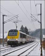 Serie 3000/246412/--winter-in-luxemburg---auf - Winter in Luxemburg - Auf der kurvenreichen Nordstrecke gibt es nur wenige Stellen, an denen es mglich ist, das Aufwirbeln des Schnees durch die Zge auf den Chip zu bannen. Am 22.01.2013 hat es geklappt, als die 3004 den IR 116 Luxembourg - Liers durch die verschneite Ortschaft Enscherange zog. (Jeanny)