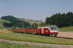Die Re 456 142 der Vereinigten Huttwil Bahnen VHB mit einem aus zehn Wagen bestehenden Sonderzug bei Gondiswil unterwegs im Sommer 1984.