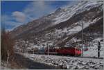Bei überraschend wenig Schnee fährt eine MGB HGe 4/4 mit ihrem Reisezug kurz nach Täsch Zermatt zu.