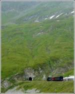 Ein kleiner Zug in einer grandiosen Landschaft. Ein DFB Dampfzug wartet am 01.08.2008 an der Station Furka auf die Weiterfahrt durch den 1.874 m langen Furkascheiteltunnel, bevor er den Abstieg nach Gletsch in Angiff nimmt. (Jeanny)
