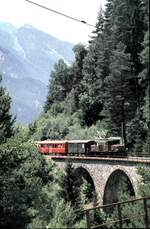 albulabahn-unesco-weltkulturerbe/759008/rhb-ge-66-i-nr413-mit RhB Ge 6/6 I Nr.413 mit Personenzug mit Güterbeförderung auf dem Schmittentobel im August 1989.