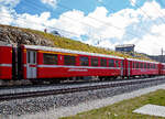 Der 4-achsige Personenwagen RhB AB 1542, ein verkrzter 1./2.Klasse Einheitswagen I (EW I) mit Aluminiumwagenkasten am 06.09.2021 bei der Station Ospizio Bernina im Zugverband.