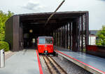 dolderbahn/739458/der-elektrischer-zahnradtriebwagen-bhe-12-nr Der elektrischer Zahnradtriebwagen Bhe  1/2 Nr. 2 der Dolderbahn steht am 06.06.2015 in der Bergstation zur Talfahrt bereit

Die beiden Elektrischer Zahnradtriebwagen Bhe  1/2 der Dolderbahn
Im Jahr 1972 stellte die Dolderbahn- Betriebs AG den Seilbahnbetrieb ein, verlängerte die Strecke um rund 500 m auf 1,3 km und verlegte eine Lamellenzahnstange (System von Roll) in das erneuerte Gleis. Für den Zahnradbetrieb lieferte die SLM 1973 zwei zweiachsige Zahnradtriebwagen. Jeder dieser Zahnradtriebwagen hat talseitig eine Triebachse und bergseitig eine Bremsachse. Ein im Untergestell in Längsrichtung angeordneter Fahrmotor treibt über eine Kardanwelle und ein zweistufiges Getriebe das Triebzahnrad an. Die Verbundbauweise des Wagenkastens mit dem Untergestell ergibt eine selbsttragende, leichte und solide Konstruktion.  Volle Betriebssicherheit wird durch eine elektrische Widerstandsbremse, eine Zahnradbremse sowie eine Klinkenbremse gewährleistet.

TECHNISCHE DATEN:
Hersteller: SLM (Schweizerische Lokomotiv- und Maschinenfabrik), Winterthur
Elektrischen Ausrüstung: BBC (Brown, Boveri & Cie. AG), Baden
Spurweite: 1.000 mm (Meterspur)
Zahnstangensystem: von Roll
Achsformel: 2z
Max. Steigung: 196 ‰
Länge über Puffer: 11.520 mm
Achsabstand: 5.400 mm
Laufraddurchmesser: 690 mm
Teilkreisdurchmesser Treib- und Bremszahnrad: 573 mm
Eigengewicht: 14,4 t
Max. Zuladung: 7,8 t
Leistung: 131,5 kW (dauernd) / 149,5 kW (einstündig)
Zugkraft: 22,9 kN (dauernd) / 27,2 kN (einstündig)
Höchstgeschwindigkeit: 25 km/h (Bergfahrt) / 16 km/h (Talfahrt)
Getriebeübersetzung: 1 : 10,45
Sitzplätze: 26
Stehplätze: 74
Fahrdrahtspannung: 600 V = (DC)

Die Dolderbahn ist eine Privatbahn in der Stadt Zürich. Die Zahnradbahn erschließt das Dolder-Gebiet im Quartier Hottingen ab der Haltestelle Römerhof am Römerhofplatz auf 444 Metern über Meer und endet in der Station Dolder auf dem Adlisberg auf 606 Metern über Meer. Die Bahn dient nebst der Verbindung mit dem Wohnquartier auch als Zubringer für zwei Hotels, dem Wellenbad Dolder, der offenen Eisbahn Dolder und dem als Naherholungsgebiet dienenden Adlisberg.

Die Betreibergesellschaft wurde 1893 gegründet. 1895 wurde der Betrieb als Standseilbahn aufgenommen. Sie führte auf einer Strecke von rund 800 Metern vom Römerhofplatz zum Hotel Waldhaus Dolder auf 548 Metern über Meer.

Zur Verbindung mit dem Grand Hotel Dolder wurde am 5. Juli 1899 ein meterspuriges Tram in Betrieb genommen. Es wurde mit einem einzigen Wagen gleicher Bauart wie die StStZ-Wagen 57–84 betrieben. Die Strecke hatte keine direkte Verbindung zum Zürcher Tramnetz, jedoch sorgte die StStZ für den Unterhalt des Motorwagens und stellte während einer längeren Revision einen Ersatzwagen. Am 31. Dezember 1930 wurde das Dolder-Tram eingestellt und ein Bus übernahm die Verbindung zwischen Waldhaus und Grand Hotel.

Zwischen 1972 und 1973 wurde die Standseilbahn durch eine Zahnradbahn ersetzt und die Strecke bis zum Grand-Hotel Dolder verlängert. Weil dazu eine Kurve nötig war, wurde aus der Seil- eine Zahnradbahn. Seither misst sie 1.328 Meter und überwindet dabei eine Höhendifferenz von 162 Metern mit einer Neigung von maximal 19,6 Prozent. Weitere Vorteile gegenüber einer Standseilbahn sind, die Bahntrasse kann besser dem Gelände angepasst werden, die Ausweichstelle muß nicht genau in der Mitte der Bahnstrecke liegen. Zudem ist ein Einwagenbetrieb oder ein späterer Ausbau für automatischen Betrieb möglich.