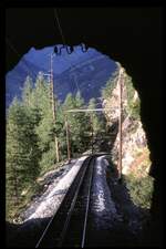Gornergratbahn Tunnelausfahrt. Die Drehstromleitung ist hier deutlich an der Tunneldecke zu erkennen,am 22.08.1979. Ebenso weitere Details, wie Zahnstange, Holzmasten und Ausleger, Tunnel aus Felsen gebrochen.