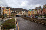 Karlsbad (Karlovy Vary) am 18.04.2023, hier in der entgegen gesetzten (nrdlichen) Blickrichtung:  Rechts von dem kanalisierten Flu Tepl (Tepl) die Marien-Magdalenenkirche und links davon die 1984