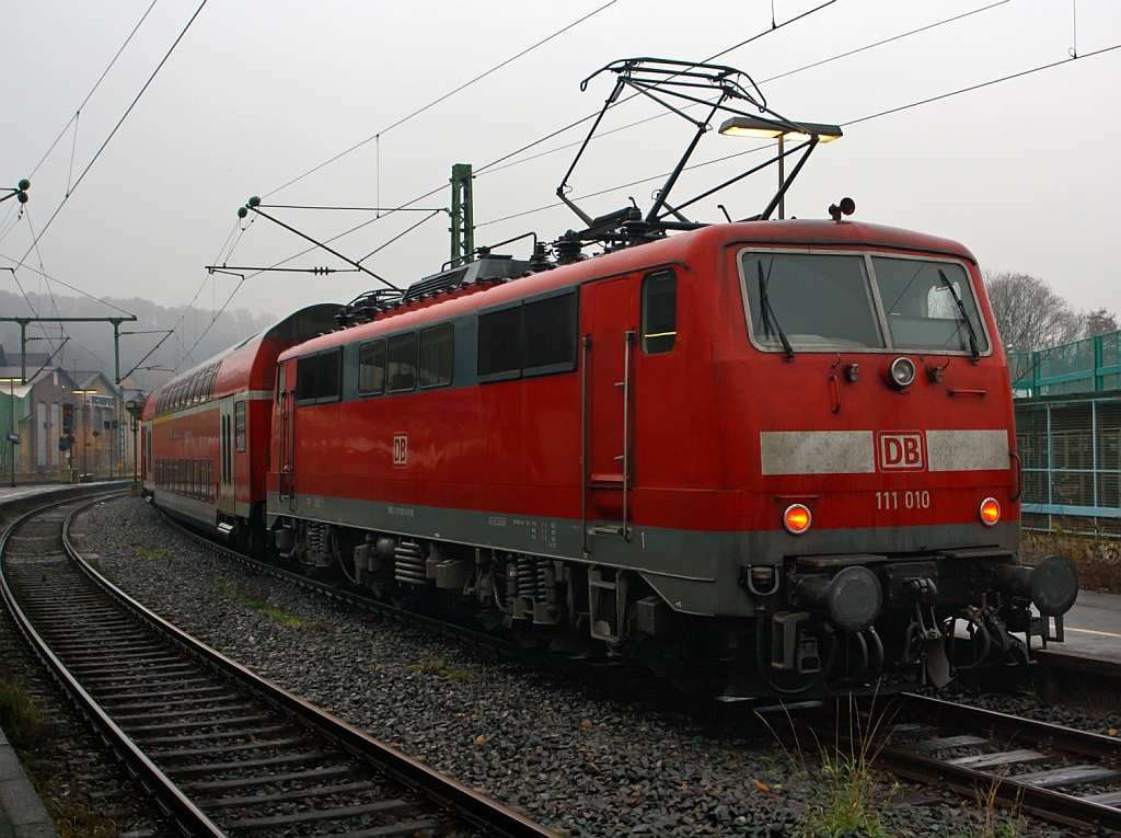 111 010-5 als Schublok des RE 9 (rsx - Rhein-Sieg-Express) Siegen - Köln - Aachen am 18.11.2012 beim Halt im Bahnhof Betzdorf/Sieg.
Von den Loks der Baureihe 111 wurden zwischen 1974 bis 1984 insgesamt 227 Stück von verschiedenen Herstellern (AEG, BBC, Henschel, Krauss-Maffei, Krupp, Siemens) gebaut, 222 Stück sind noch im Bestand der DB.
Sie haben die Achsformel Bo'Bo', die Länge über Puffer ist 16.750 mm. Sie haben 4 Fahrmotoren á 905 kW = 3.620 kW Leistung, welche die 83 t schwere Lok, bei einer Anfahrzugkraft von 274 kN, auf eine Höchstgeschwindigkeit von 160 km/h bringen.

Teilweise, wie hier, haben Lok der 1. Bauserie einen Scheren-Stromabnehmern der Bauart DBS 54a (Dozler-Bahn-Stromabnehmer, Entwicklungsjahr 1954, Variante a). . Da 1976 die zuerst verbauten Einholm-Stromabnehmer SBS 65(Siemens-Bahn-Stromabnehmer, Entwicklungsjahr 1966), mit denen der BR 103 getauscht wurden. Es war mehrfach vorgekommen, dass die Scherenstromabnehmer bei der BR 103 die Fahrleitung herunter rissen.