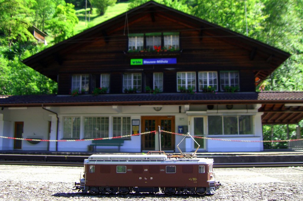 1/87 Roco Modell der BLS Ae 4/4 251 vor dem originalgroen Bahnhofsgebude von Blausee Mitholz, das es auch als 1/87 Modell von Kibri gibt. (04.08.2007)