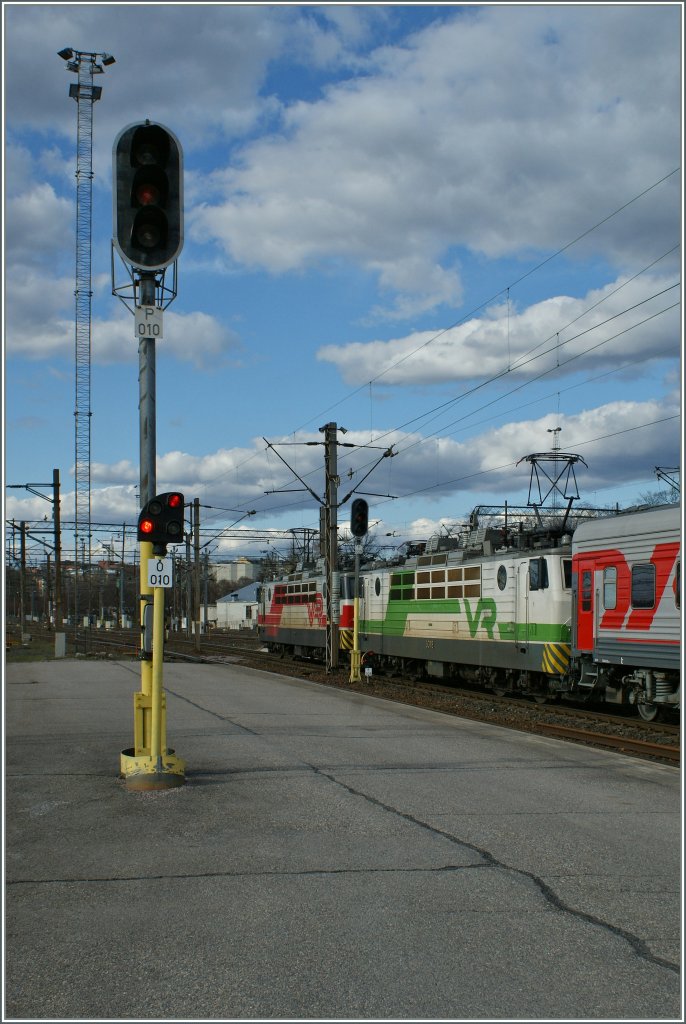 Bahnamiente in Helsinki: ein Hauptsignal, ein Zwergsignal und der viel zu lange Nachtzug nach Moskau am 29. April 2012. 