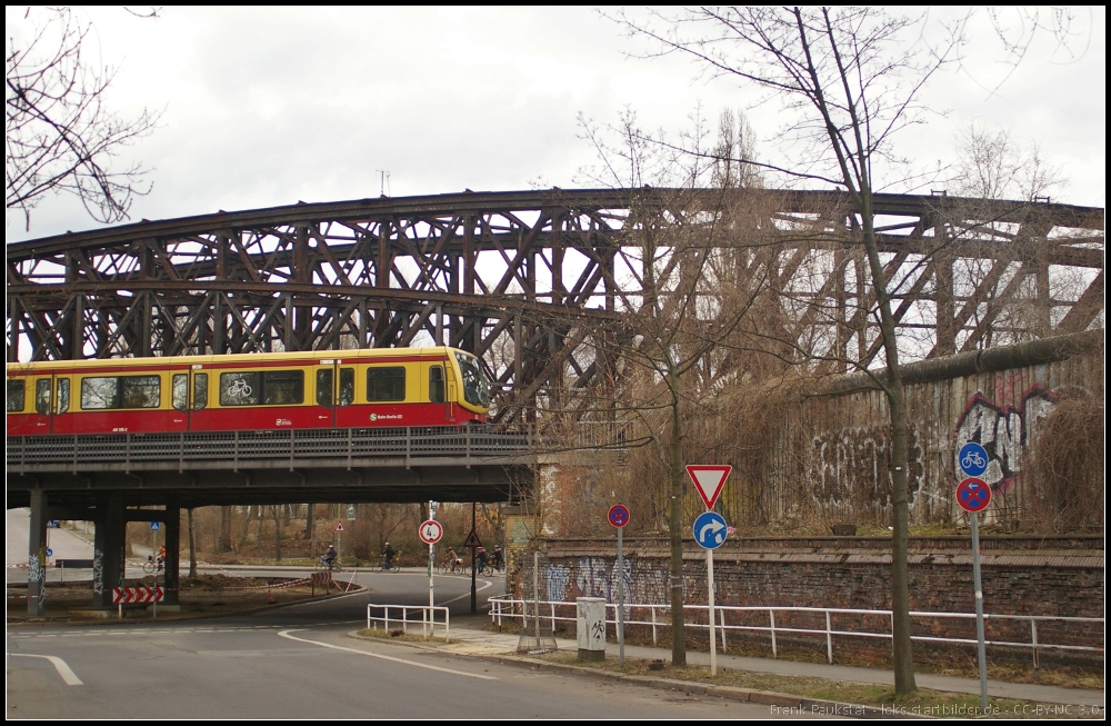 Blick auf die Liesenstra�enbr�cke mit vorbeifahrender S-Bahn und einem Mauerst�ck in Berlin Humboldthain