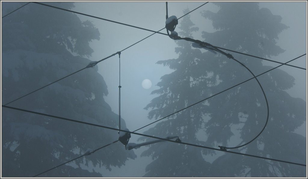 Blick durch die Fahrleitungen auf die vom Nebel umh�llte Sonne.
(19.12.2012)