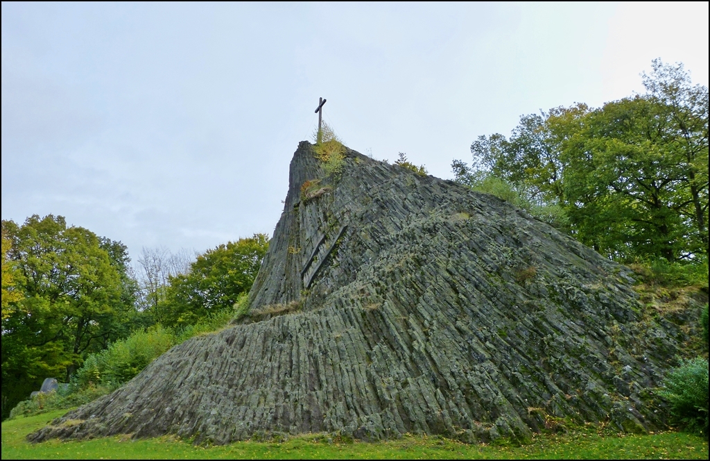 Der Druidenstein ist ein kegelf�rmiger Basaltfels im N�rdlichen Hellerbergland oberhalb der Stadt Kirchen an der Sieg im Ortsbezirk Herkersdorf, Landkreis Altenkirchen. Der Basaltkegel erhebt sich auf 431 m in zirka 20 Meter H�he. Der Druidenstein ist etwa 25 Millionen Jahre alt (Jung-Terti�r) und nimmt eine Fl�che von zirka 100 m� ein. Seine ungew�hnliche Form erhielt er, als sich Lava durch die devonische Grauwacke des Grundgebirges hindurchzw�ngte und anschlie�end erstarrte. So bildeten sich senkrecht zur Abk�hlungsfl�che prismatische S�ulen heraus.Durch Erosion blieb nur noch der harte Basaltkern �brig, allerdings „schrumpft“ diese Kuppe immer weiter. Auch andere Ereignisse haben die Gr��e des Basaltkegels reduziert. Der Druidenstein ist vermutlich bereits von den Kelten als religi�se St�tte und als Versammlungsort genutzt worden. Die oberste Spitze wurde wohl aus taktischen Gr�nden w�hrend des Drei�igj�hrigen Krieges abgebrochen, damit sich feindliche Truppen nicht daran orientieren konnten. Damals war die Spitze n�mlich noch weithin sichtbar und kaum Wald vorhanden. Im Jahr 1869 wurde der Druidenstein unter Naturschutz gestellt. Heute z�hlt er zu rund 3.000 Naturdenkmalen des Landes Rheinland-Pfalz. 1979 wurde der Druidenstein von einem Blitz getroffen. Der Einschlag war so gewaltig, dass der Basaltkegel danach mit sechs Stahlbetonbalken gest�tzt werden musste. Au�erdem wurde der Druidenstein unter anderem als Steinbruch f�r den Stra�enbau genutzt. 14.10.2012 (Jeanny)
