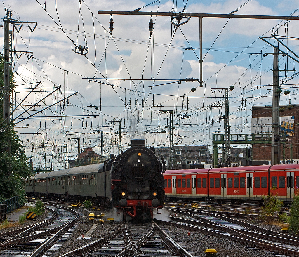Die Dreizylinder-Schnellzuglokomotiven 01 1066 ex DB 012 066-7 der UEF am 07.07.2012 mit einem Sonderzug bei der Einfahrt in den Hbf Kln. Bemerkenswert ist das der Zug aus 12 vollbesetzten Wagen bestand und alleine von der 01 gezogen wurde. 
Die 011066 wurde im Jahr 1940 von der BMAG (vormals L. Schwartzkopff) an die Deutsche Reichsbahn ausgeliefert. Ursprnglich hatte die Lok eine Stromlinienverkleidung, die aber nach dem Ende des 2. Weltkriegs entfernt wurde. 
Im Jahr 1954 bekam die 011066 einen neuen Hochleistungskessel, 1957 eine lhauptfeuerung. Am 31. Mai 1975 absolvierte die Lok ihre letzte planmige Fahrt bei der DB.