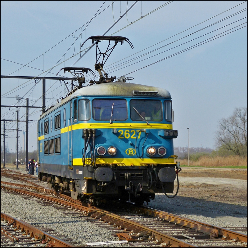 Die HLE 2627 beim Umsetzen am 24.03.2012 im abgesicherten Bereich des Antwerpener Hafens whrend der Abschiedsfahrt fr diese tollen Loks. (Jeanny)

Die Geschichte der Srie 26:

Mit der zunehmenden Elektrifizierung auf belgischen Gleisen bentigte die SNCB/NMBS Mitte der sechziger Jahre weitere leistungsstrkere Lokomotiven. Von BN in Nivelles wurden im Jahr 1964 fnf Vorserienloks an die SNCB/NMBS fr ausgedehnte Prfprogramme geliefert.

Die von BN gelieferten Fahrzeuge basierten dabei auf der franzsischen Serie BB 9400. Der mechanische Teil wurde von BN gefertigt, der elektrische Teil von ACEC. Die Drehgestelle der Loks wurden hingegen in Frankreich gefertigt. Die Vorserienfahrzeuge erhielten die Betriebsnummern 126.001 bis 126.005.

Nachdem die Vorserie die Testphase berstanden hatte gab die SNCB/NMBS 30 Serienloks in Auftrag. Gegenber den Vorserienfahrzeugen konnte die Leistung nochmals gesteigert werden. Whrend die Fahrzeuge der Vorserie noch eine Leistung von 2.240 kW erbrachten, lieferten die Serienloks 2.470 kW.

Diese neuen Serienloks wurden als Unterbauart 126.1 eingereiht. Die Fahrzeuge erhielten so die Ordnungsnummern 126.101 bis 126.115. Das die Ziffernvergabe schon bei 126.115 endete hing damit zusammen, da sich die Auslieferung der Fahrzeuge mit der Einfhrung des neuen Nummernsystems zum 01.01.1971 zeitlich berschnitt.

Ab dem 01.01.1971 wurden alle Fahrzeuge der frheren Baureihe 126 als Baureihe 26 eingruppiert. Im neuen Nummernsystem wurde dann nicht mehr zwischen Vorserie und Serie unterschieden. So bekam die Baureihe 26 die fortlaufende Numerierung von 2601 bis 2635, wobei 2601 bis 2605 die Vorserienfahrzeuge enthielt. Etwa zur gleichen Zeit wurden die Vorserienmaschinen technisch an die Serienfahrzeuge angepat.

In den siebziger Jahren wurden alle Fahrzeuge fr den Einbau einer automatischen Kupplung vorbereitet. Diese wurde allerdings nie eingebaut. Zur gleichen Zeit wurden die einfachen Lampen der Loks durch Doppelleuchten ersetzt. Paralell dazu wurden sie fr den Betrieb in Doppeltraktion ausgerstet. Interessanterweise beschrnkte man sich dabei nicht auf die Tatsache, die Loks der Srie 26 miteinander zu vernetzen, sondern die Loks der Srie 23 wurden auch dementsprechend umgerstet, sodass sie auch untereindander im Doppelpack fahren konnten. Ein Konzept, welches in Belgien einzigartig und auch im Rest der Welt sehr selten ist.

Ausgeliefert wurden alle Fahrzeuge in dunkelgrn. Ein groer Teil der Loks bekam Ende der siebziger Jahre eine gelbe Lackierung mit blauen Streifen. Zwischen 1980 und 1995 wurden dann jedoch alle Fahrzeuge in das heutige blau/gelbe Lackierung der SNCB/NMBS berfhrt. 

Die technischen Daten der Srie 26:

Baujahre: 1969-1972 (Vorserie: 1964)
Hersteller: BN (La Brugeoise et Nivelles) und ACEC (Atelier de Contruction lectriques de Charleroi)
Dauerleistung: 	2.470 kW (Vorserie: 2.240 kW)
Numerierung: 2606 – 2635 (Vorserie: 2601 – 2605)
Stckzahl: 30 (Vorserie: 5)
Hchstgeschwindigkeit: 130 km/h
Dienstgewicht: 	82,4 t.
Lnge ber Puffer: 17.250 mm
Hhe: 4.379 mm
Stromsystem : 3 kV
Achsfolge: Bo'Bo'



