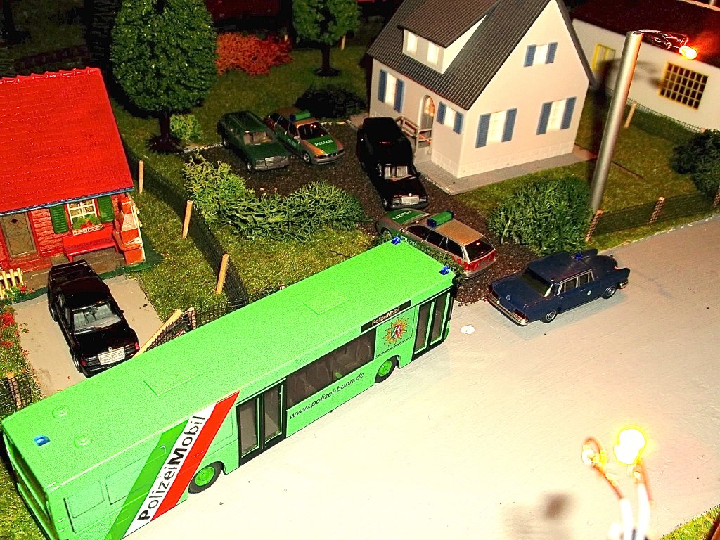 Dieser MAN NL263 als mobile Einsatzzentrale befindet sich an einem Tatort, um f�r Vernehmungen der Zeugen etc. zur Verf�gung zu stehen. Im Hintergrund stehen 3 Polizeiautos und ein selbst umgebauter Leichenwagen.