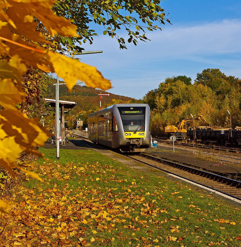 Ein Stadler GTW 2/6 der Hellertalbahn fhrt am 18.10.2012 vom Bahnhof Herdorf weiter in Richtung Betzdorf/Sieg. Im Hintergrund verld ein Atlas Zweiwegebagger alte Schellen auf Res-Wagen.