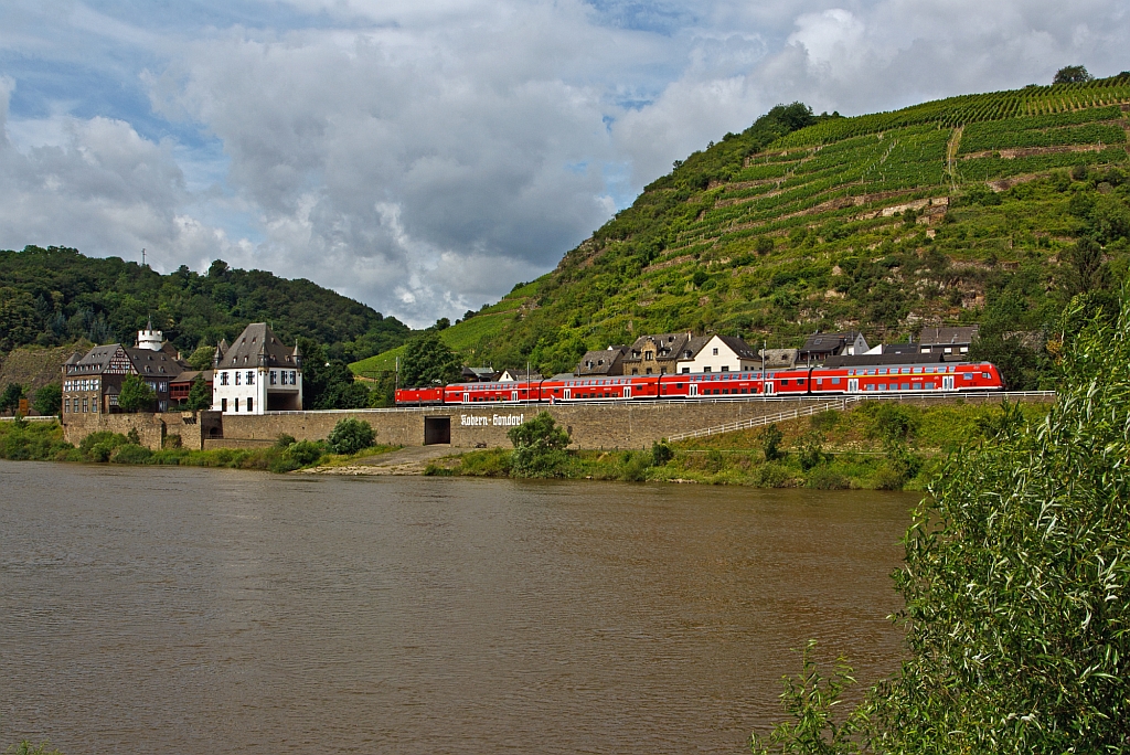 Eine 143er schiebt den RE 1 Mosel-Saar-Express (Saarbrcken - Trier - Koblenz) entlang der Mosel abwrts in Richtung Koblenz, hier am 18.07.2012 bei Kobern-Gondorf.