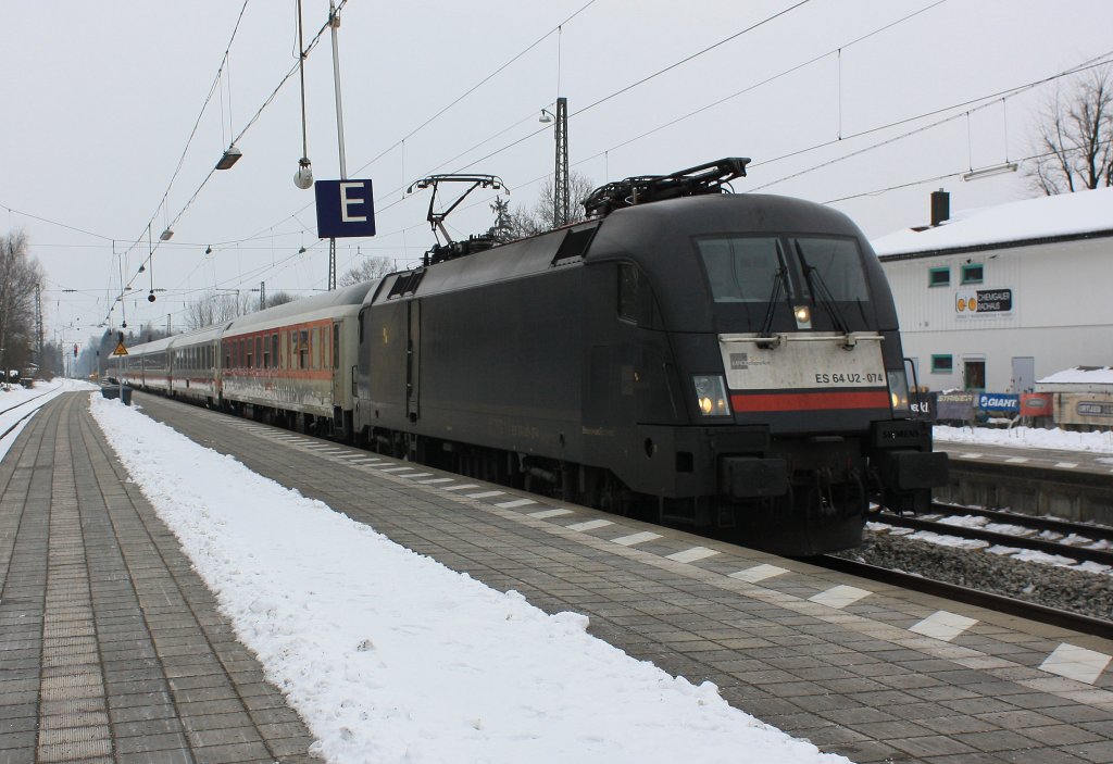 ES 64 U2-074 von  MRCE  vor dem IC  Knigssee , am 25. Februar 2013, bei der Einfahrt in den Bahnhof von Prien am Chiemsee.