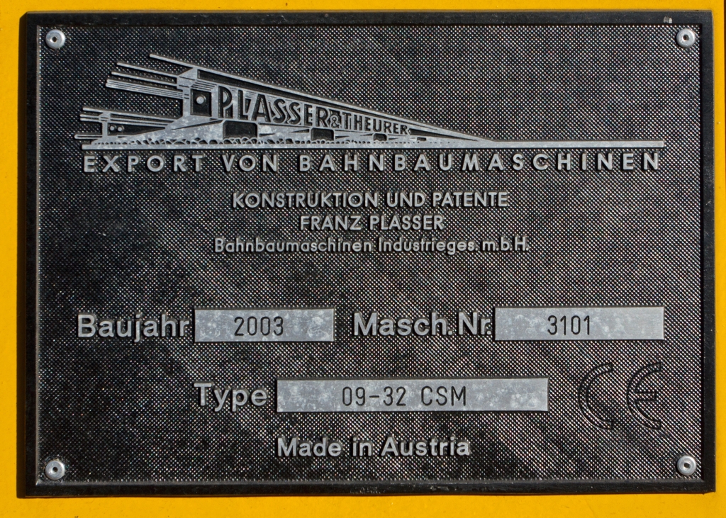 Fabrikschild Plasser und Theurer Zweischwellenstopfmaschine 09-32 CSM (Schweres Nebenfahrzeug Nr. 97 40 68 006 17-6) der DB Bahnbau Gruppe, abgestell am 28.10.2012 in Siegen-Weidenau. 