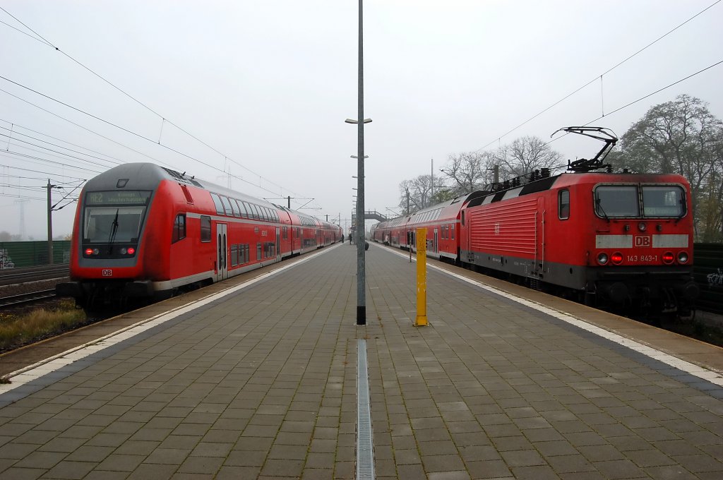 Links steht die RE2 (RE 38137) nach K�nigs Wusterhausen gezogen von der 112 104-5 und rechts steht die 143 843-1 die den RB21 (RB 28011) nach Potsdam Griebnitzsee geschoben hat in Wustermark. 02.11.2010