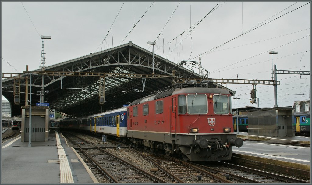 Re 4/4 II 1112 mit einem EW I/II Regionalzug nach Vallorbe bei der Abfahrt in Lausanne. 
12. Juni 2012