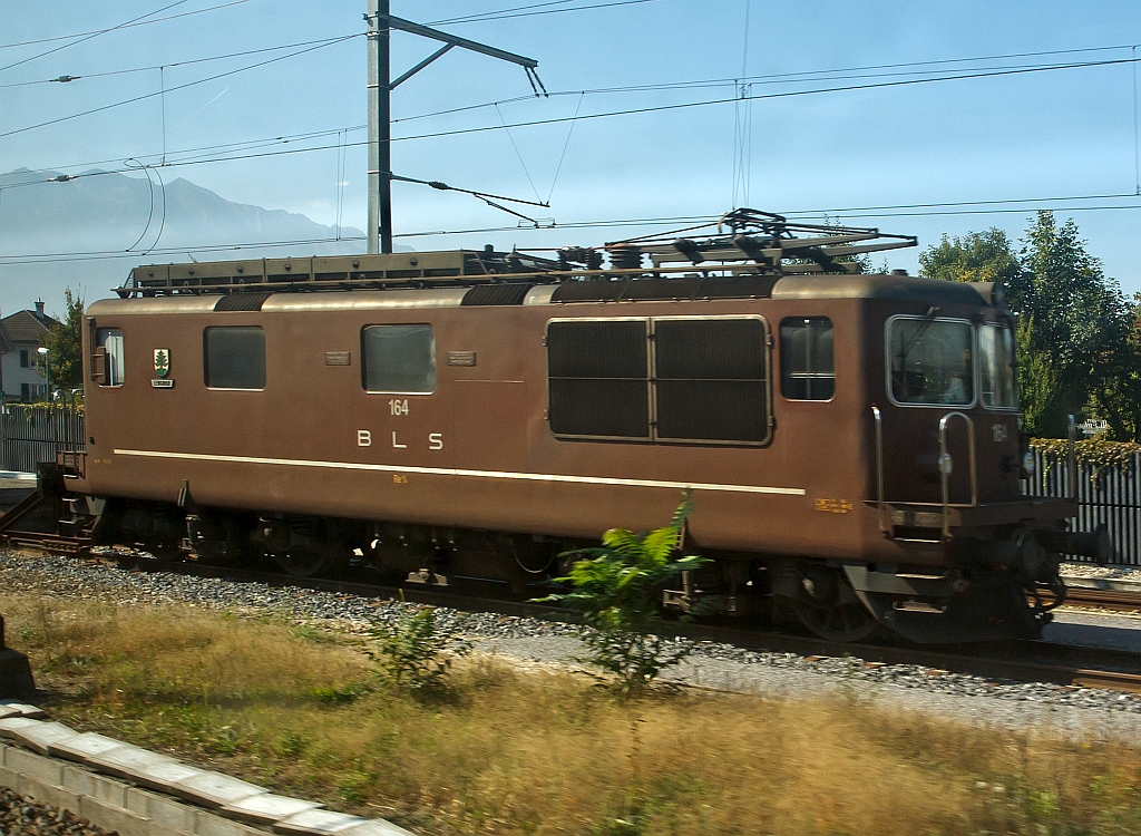 Re 4/4 (Re 425) 164  (Lengnau) der BLS, ex Ae 4/4 II 264, abgestellt am 30.09.2011 bei Bern, fotografiert aus einem fahrenden ICE. 
Die Lok wurde 1967 bei SLM unter Fabriknummer 4636 gebaut. 

Die Loks wurde als Universallokomotive mit guter Bergleistung beschafft, um die Zge mit hheren Geschwindigkeiten befrdern zu knnen und um die Lokomotiven der Grndungsjahre abzulsen. Die Dauerleitung der Koks betrgt 4980 kW (6770 PS).

Die Re 4/4 ist eine Neuentwicklung der BLS und SLM aufgebaut auf die Ae 4/4, der ersten laufachslosen Hochleistungslokomotive der Welt. Das ist an der Kastenform eindeutig zu erkennen, die Einstiege an der Lokfront wurde von der Ae 4/4 bernommen. Das Fahrgestell ist hnlich demjenigen der SBB Re 4/4 II. Doch schon da hren die Gemeinsamkeiten zu dieser auch sehr erfolgreichen Baureihe auf. So wird die Kraft mit einer anders konstruierten Tiefzuganlenkung und Seilzug auf die Schienen gebracht. Statt Sandereinrichtungen besitzt die Lok Schienendsen. Bei vielen Versuchen mit z. T. auslndischen Lokomotiven stellt die Re 4/4 noch heute ihre enorme Leistungsfhigkeit am Berg unter Beweis. Einen 630-Tonnen-Zug kann die Lok auf einer 26-‰-Steigung mit 80 km/h befrdern. 

