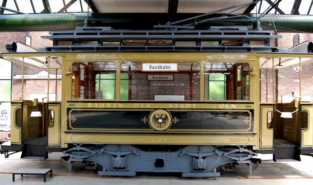 Stra�enbahnmuseum K�ln in Thielenbruch.
Der Triebwagen 407 steht f�r die erste Generation des elektrischen Bahnbetriebs in K�ln, der am 15. Oktober 1901 begann.
Baujahr: 1902, Hersteller: van der Zypen & Charlier, K�ln-Deutz (mechanischer Teil)Siemens & Halske, Berlin (elektrischer Teil).
Der Wagen bot den Fahrg�sten 16 Sitzpl�tze auf L�ngsb�nken in einem durch Schiebet�ren von den Vorr�umen abgetrennten Innenraum. 
Das Sitzen in der Elektrischen war so eng, dass „Damen mit ungesch�tzten Hutnadeln“ von der Fahrt ausgeschlossen wurden. (10.05.2009)





