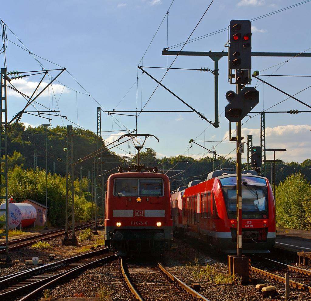 Zugbegenung in Betzdorf (Sieg) am 10.08.2012 - Links fhrt der RE 9 (Rhein-Sieg-Express) Aachen - Kln - Siegen ein mit Zuglok 111 075-8, Rechts fhrt die RB 95  (Dillenburg - Siegen - Betzdorf - Au/Sieg ) zwei gekuppelte  LINT 27 (640 028 und 640 004) weiter in Richtung Au (Sieg). Hier mit starkem Streiflicht.