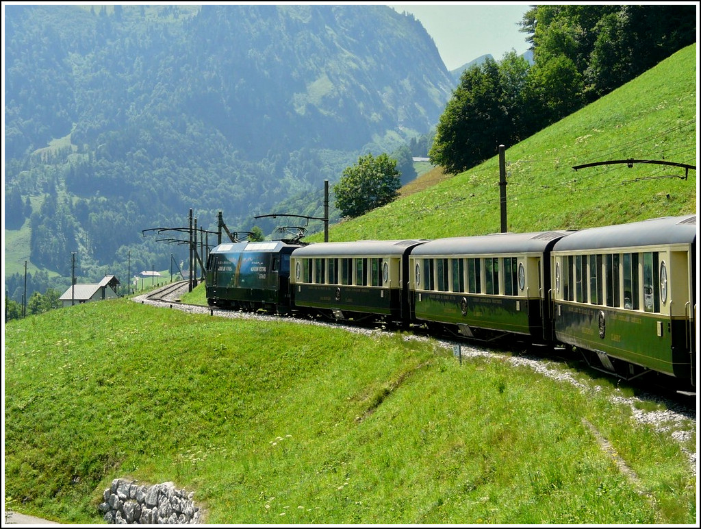 Zwischen Gstaad und Chteau d'Oex scheint die Zeit stehen geblieben zu sein. Die alten Fahrleitungsmasten passen exzellent zu den Pullmanwagen, nur die moderne Ge 4/4 strt etwas die romatische Idylle. 31.07.2008 (Jeanny)