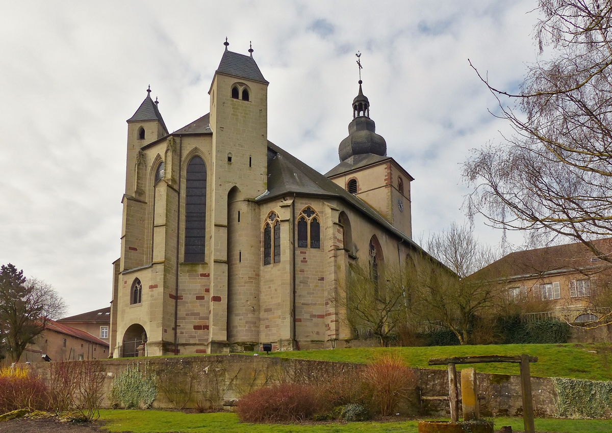 . Bouzonville - Die ehemalige Klosterkirche Heilig Kreuz (Sainte Croix) in Bouzonville (deutsch Busendorf, lothringisch Busendroff) im D�partement Moselle in der Region Lothringen. 03.04.2015 (Jeanny)

Die Kirche ist eine querhauslose gotische Pseudo-Basilika mit offener Vorhalle. Der Turm erhielt in der Barockzeit eine welsche Haube. Das Chorgest�hl mit fig�rlichen Schnitzereien entstammt der Barockzeit. Der Chorabschluss der Kirche verf�gt �ber zwei f�r Lothringen typische Chorflankent�rme. Das Mittelschiff ist 17 m hoch, die Seitenschiffe erreichen eine H�he von 10 m.

Die bauf�llig gewordene Apsis wurde in den Jahren 2006-2009 durch die Spenden des Vereins  Autour de l´abbatiale  und Finanzhilfen der Zivilgemeinde Bouzonville und des Generalrates der Region Mosel aufwendig renoviert. Auch die Bedachung der T�rme aus dem Jahr 1957 wurde dabei in altdeutscher Schieferdeckung erneuert und mit Balusterkn�ufen geschm�ckt. Die Kirche wurde am 8. September als historisches Monument staatlich anerkannt