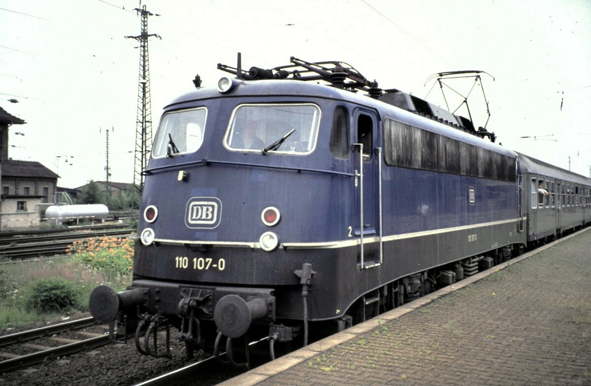 110 107-0 in Friedberg im Juni 1992. Es handelt sich um eine Kasteneinheitslok, die einen heftigen Unfall hatte und einen neuen Kasten benötigte. Da zu diesem Zeitpunkt bereits die Bügelfalte serienmäßig gebaut wurde, hat die Lok eine Bügelfalte erhalten.
