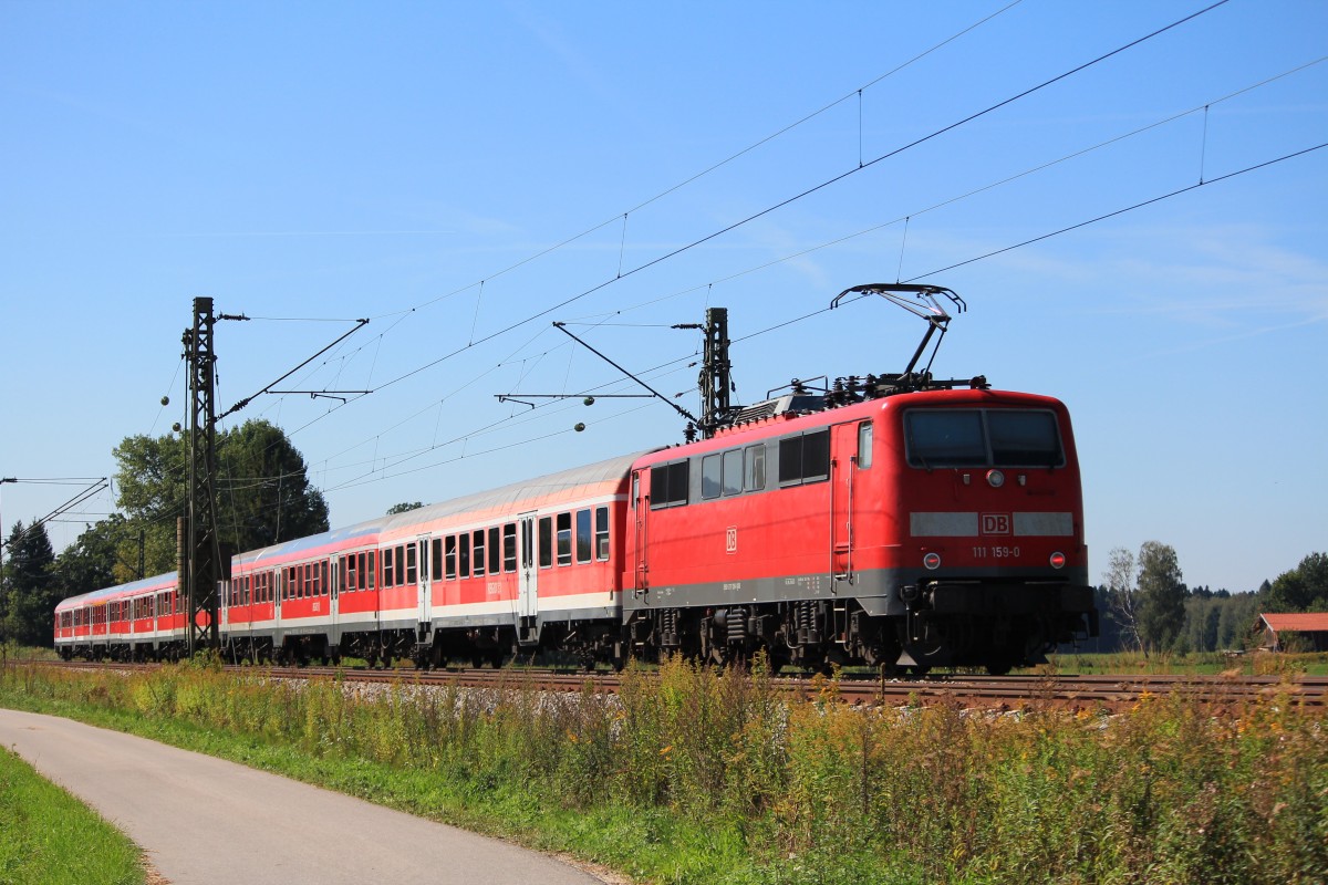 111 159-0 mit einem Regionalzug auf dem Weg nach München. Aufgenommen am 9. September 2012 bei Übersee.