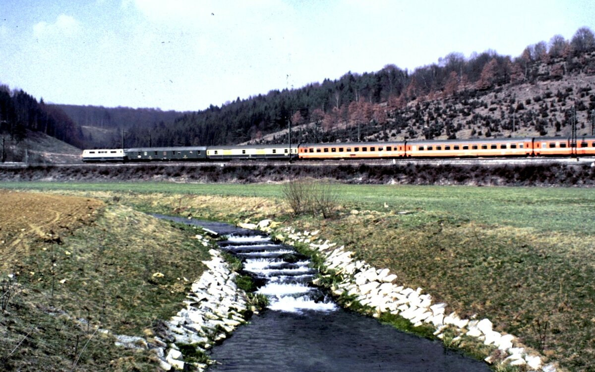 111 mit zwei Packwagen und EC Mozart bei Urspring am 02.04.1982.