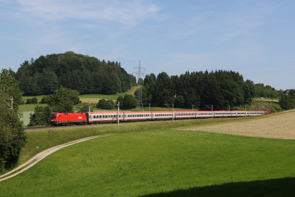 1116 148 war am 13. Juni 2025 mit einem  EC  bei Vachendorf im Chiemgau in Richtung Mnchen unterwegs.