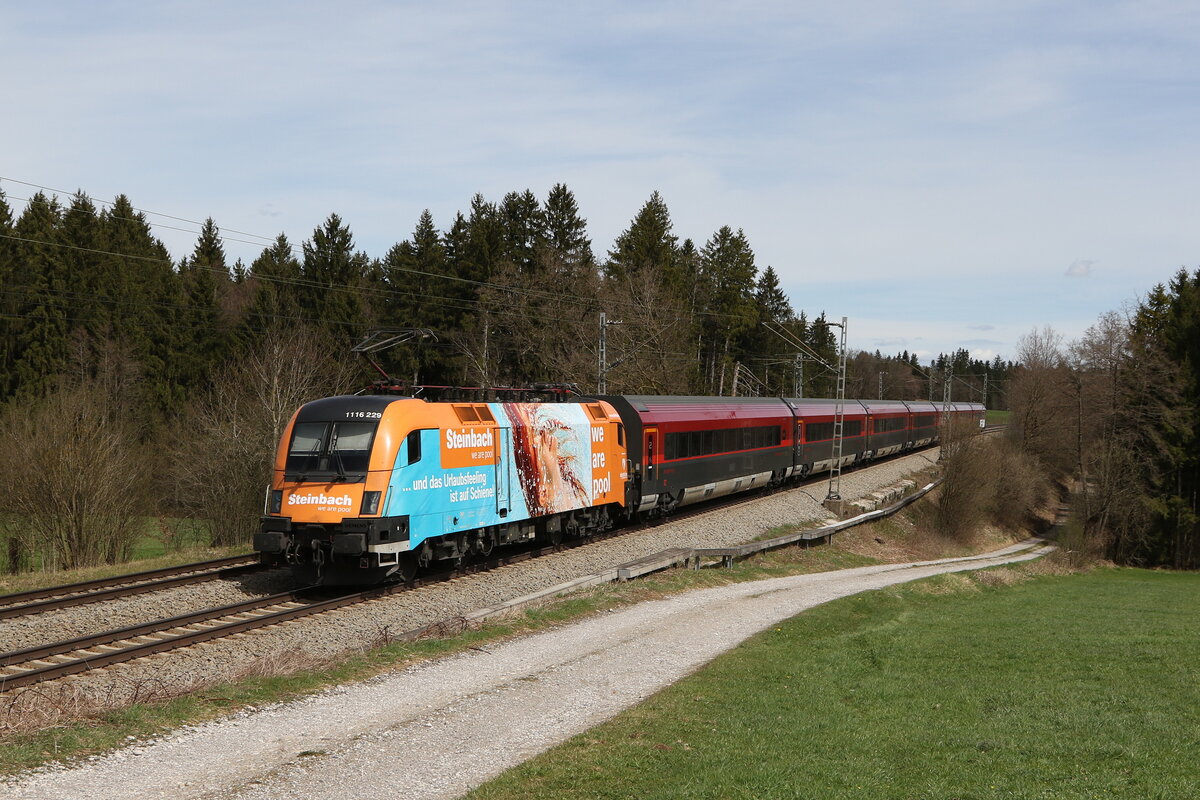 1116 229 schiebend an einem Railjet nach Salzburg. Aufgenommen am 7. April 2022 bei Grabensttt im Chiemgau.