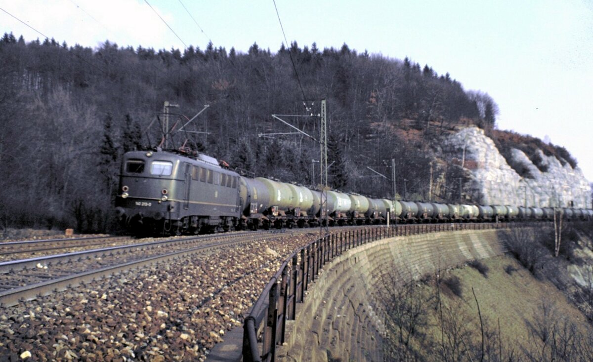 140 213-0 mit Kesselwagenganzzug auf dem Mühltalfelsendamm der Geislinger Steige am 03.04.1982.