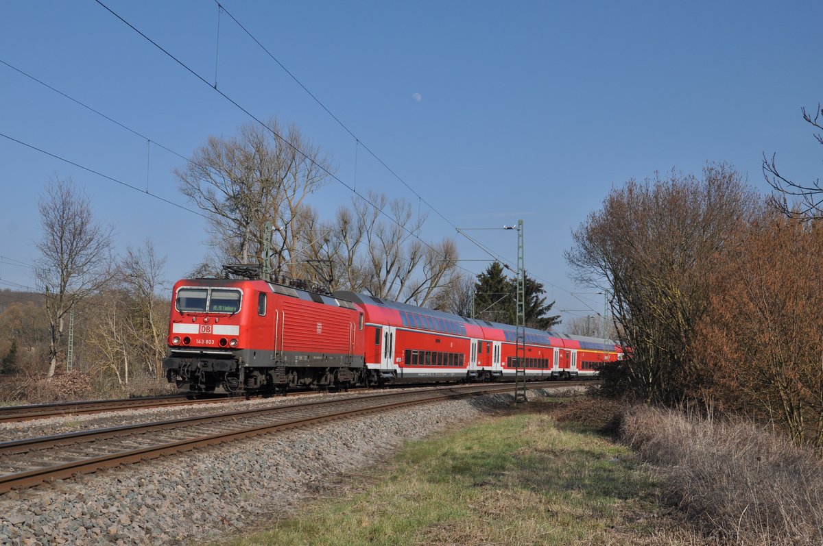 143 803 war am 24. März 2021 mit einem gedrehten RE20 auf dem Weg von Frankfurt Hbf nach Limburg(Lahn) und wurde dabei in der Einfahrt von Eschhofen aufgenommen. Grund für die gedrehte Garnitur war, dass der Zug am Vortag wegen Personen im Gleis zunächst nach Frankfurt-Niederrad gefahren ist; dort Kopf gemacht hat und dann schließlich mit Lok voraus nach Limburg gefahren ist. Zeit für eine Drehfahrt ist lediglich in der Abstellung in Frankfurt möglich, weshalb eine gedrehte Garnitur meistens dann auch 2-3 Tage unterwegs ist. 