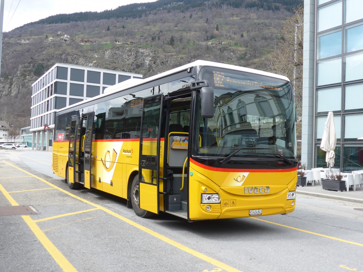 (159'675) - PostAuto Wallis - VS 424'841 - Iveco am 5. April 2015 beim Bahnhof Brig