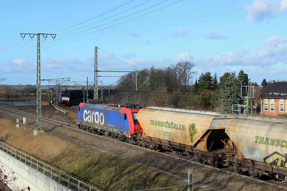 16.02.2014 10:12 Uhr - 482 044 von SBB-Cargo verläßt Stendal mit einem Transcerealeszug in Richtung Salzwedel während der Zellstoffzug von Rostock Seehafen nach Pordenone am Einfahrsignal der Wittenberger Strecke warten muß.