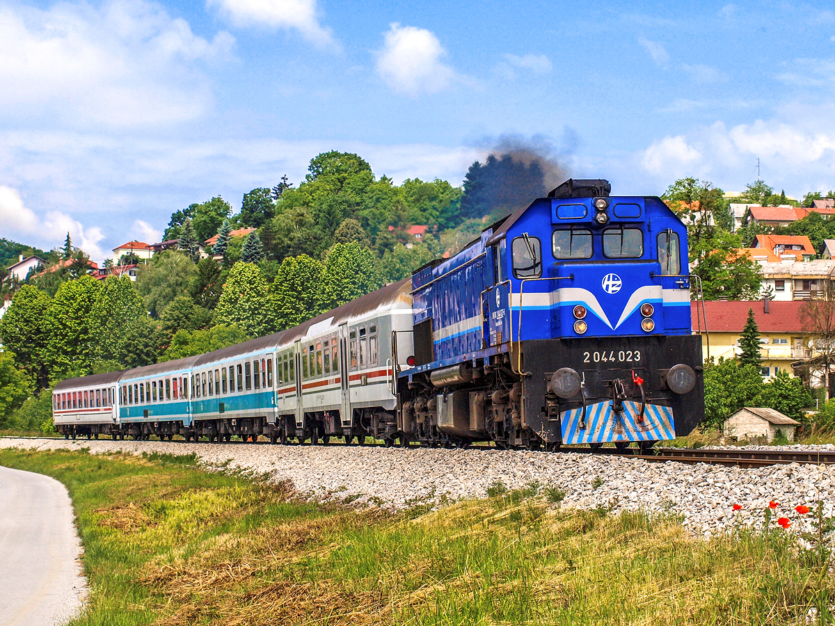 2044 023 ist eine von acht Lokomotiven ihrer Baureihe, welche im Jahr 2015 wegen Fristablaufs abgestellt und anschließend zum Verkauf angeboten wurden. Die Personenverkehrssparte der Kroatischen Eisenbahnen (HZPP) plant die Flotte der Großdiesellokomotiven rund um ein Drittel zu reduzieren, sodass eine Wiederinbetriebnahme der besagten Loks ziemlich unwahrscheinlich erscheint. Ende 2012 wurde 2044 023 von Osijek nach Zagreb umbeheimatet und war seitdem vorwiegend im Regionalverkehr nach Varazdin anzutreffen. Am Vormittag des 07.06.2013. beschleunigte sie gerade den Regionalzug 3004 von Zagreb nach Varazdin aus dem Bahnhof von Zabok. Im Zugverband befanden sich damals noch zwei Abteilwagen in der türkisen Farbgebung, welche mittlerweile ebenfalls von den kroatischen Gleisen verschwunden sind.