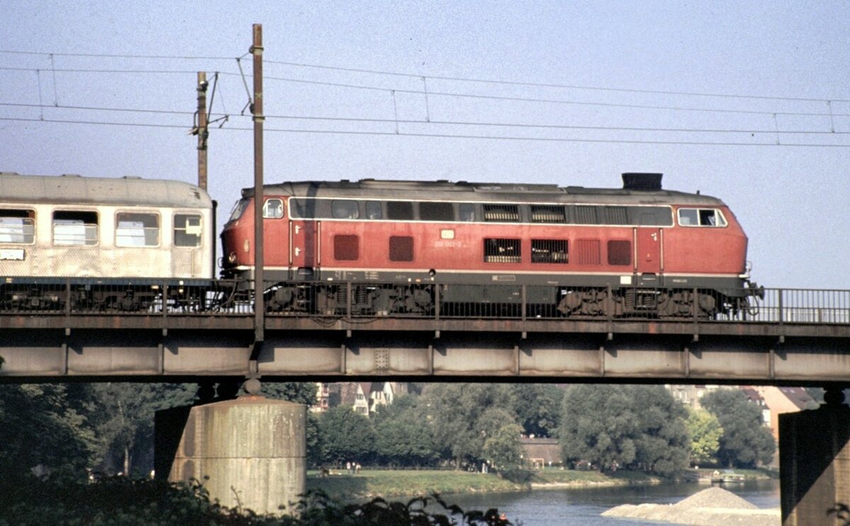 210 002-2 mit Nahverkehrszug Silberlinge auf Donaubrücke in Ulm/Neu-Ulm im September 1980.