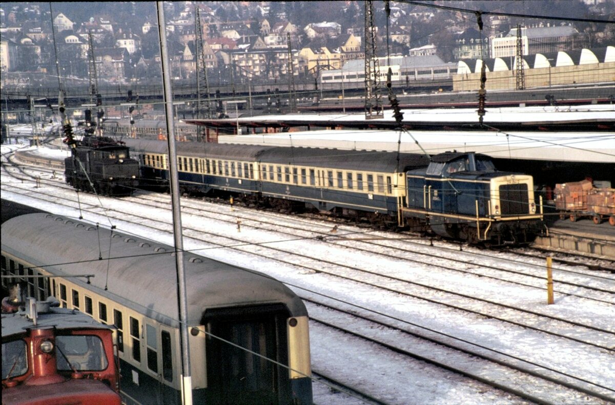 211 214-2 mit 2.Klasse Mitteleinstiegswagen Byl (b) 421 und eine 194 solo in Ulm am 13.12.1980.