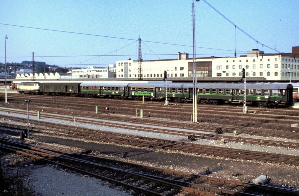 215 mit Personenzug in Ulm im Juli 1984. Der Zug besteht aus Behelfspackwagen und Umbauwagen der Allgäu-Zollern-Bahn, zu erkennen am grünen Streifen und dem Wappen auf dem Packwagen.