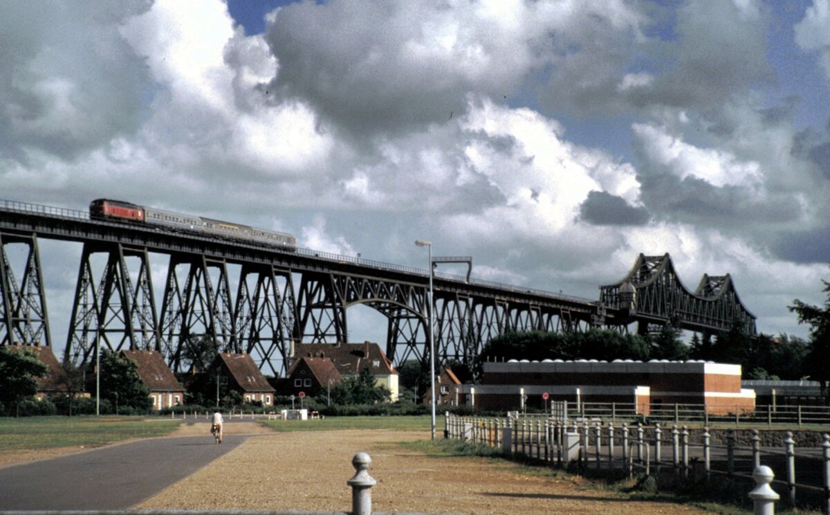 216 mit Silberling Wendezug auf der Rampe zur Nord-Ostsee-Kanal Brücke bei Rendsburg am 15.07.1985. Die eigentliche Brücke ist rechts am Bildrand erkennbar.