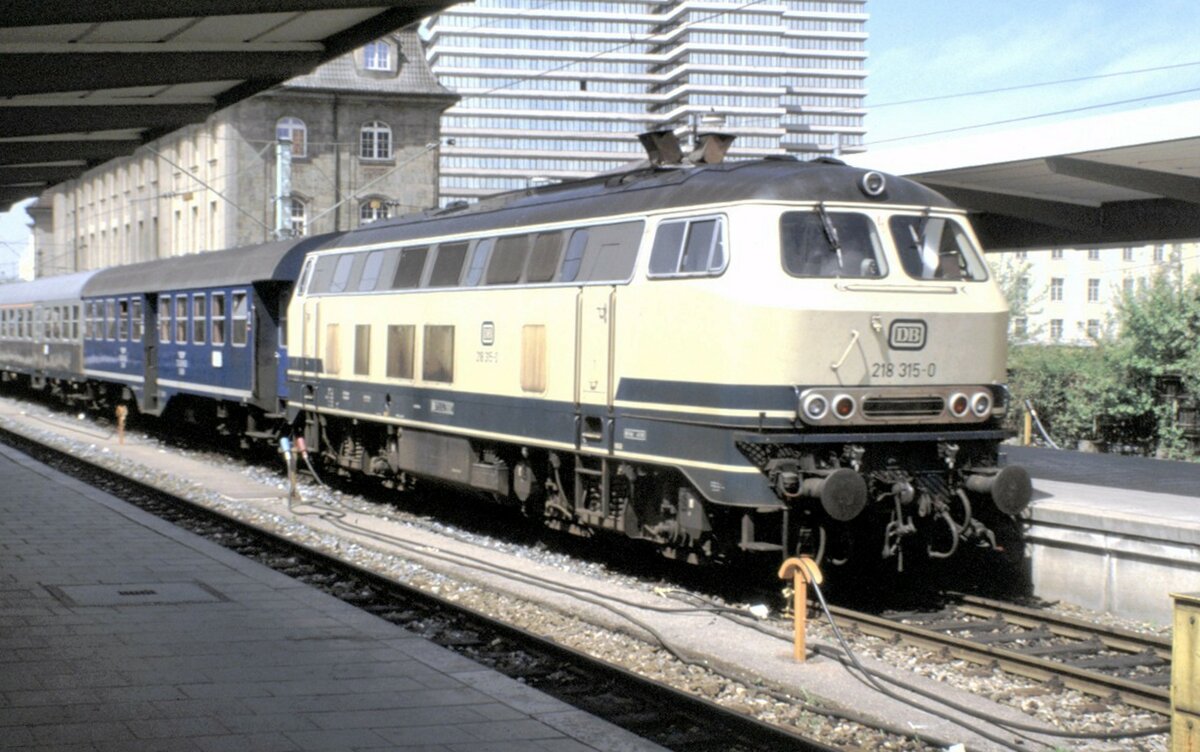 218 315-0 mit Nahverkehrszug in München am 08.05.1988. Der erste Wagen ist ein Umbauwagen der Tegernseebahn.